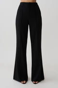 Woman wearing black high waisted suiting pants.