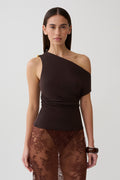 Woman wearing brown short sleeve draped hardware top.