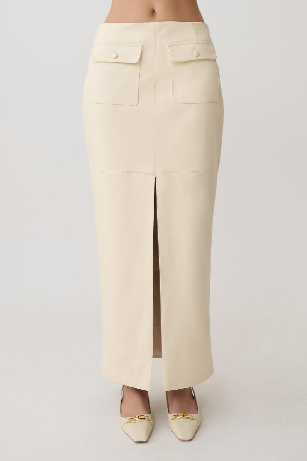 Woman wearing a white faux leather maxi skirt.