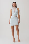 Woman wearing light blue chiffon and lace halter mini dress.