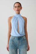 Woman wearing a blue viscose sleeveless halter top.