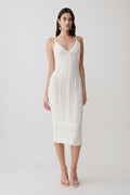 Woman wearing a white scalloped neckline pointelle midi dress.