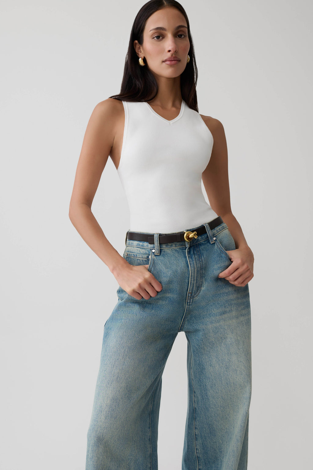 Woman wearing a knit white tank top.
