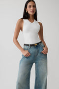 Woman wearing a knit white tank top.