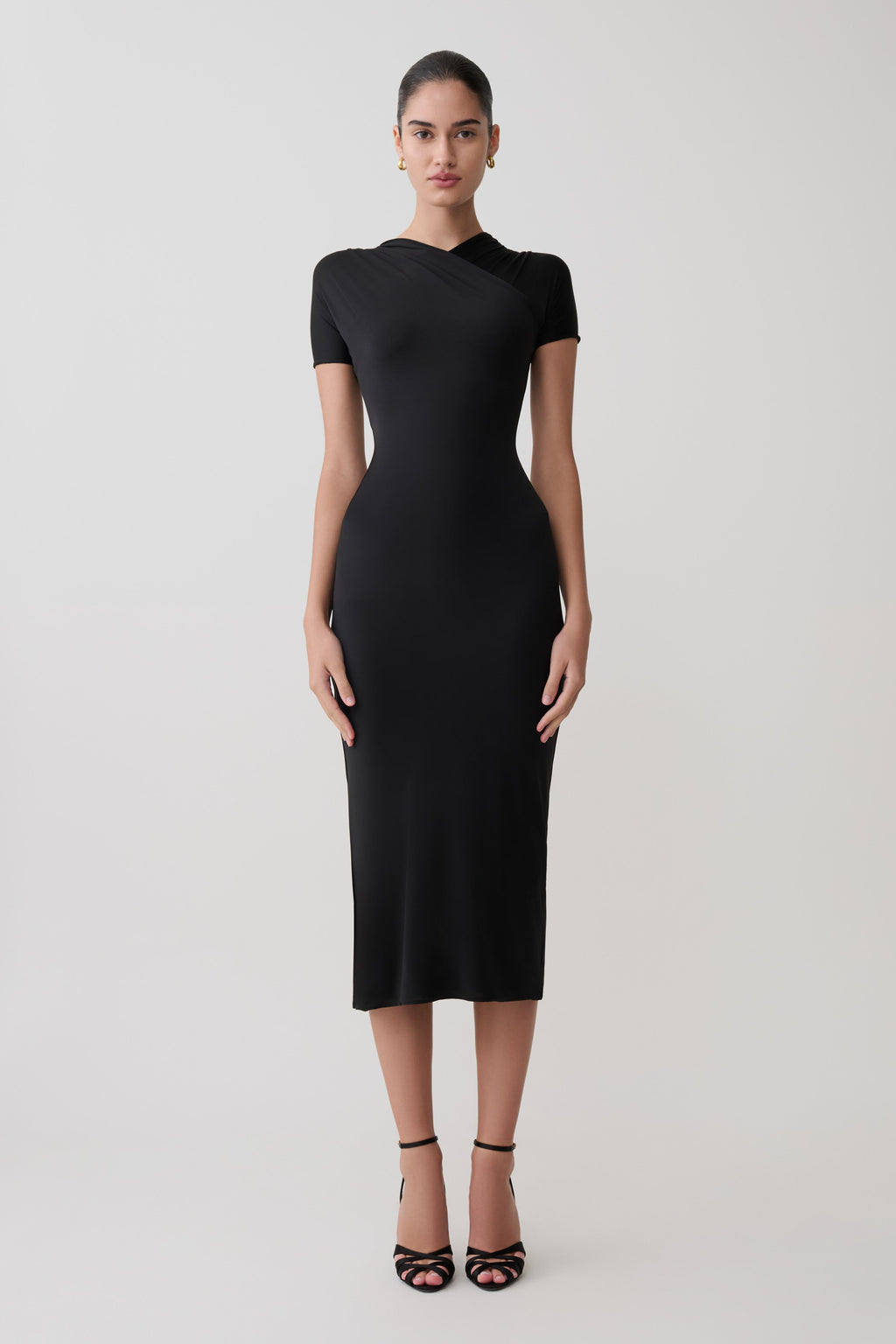 Woman wearing a black dress on a white background.