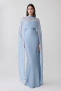 Woman wearing a light blue chiffon overlay maxi dress.