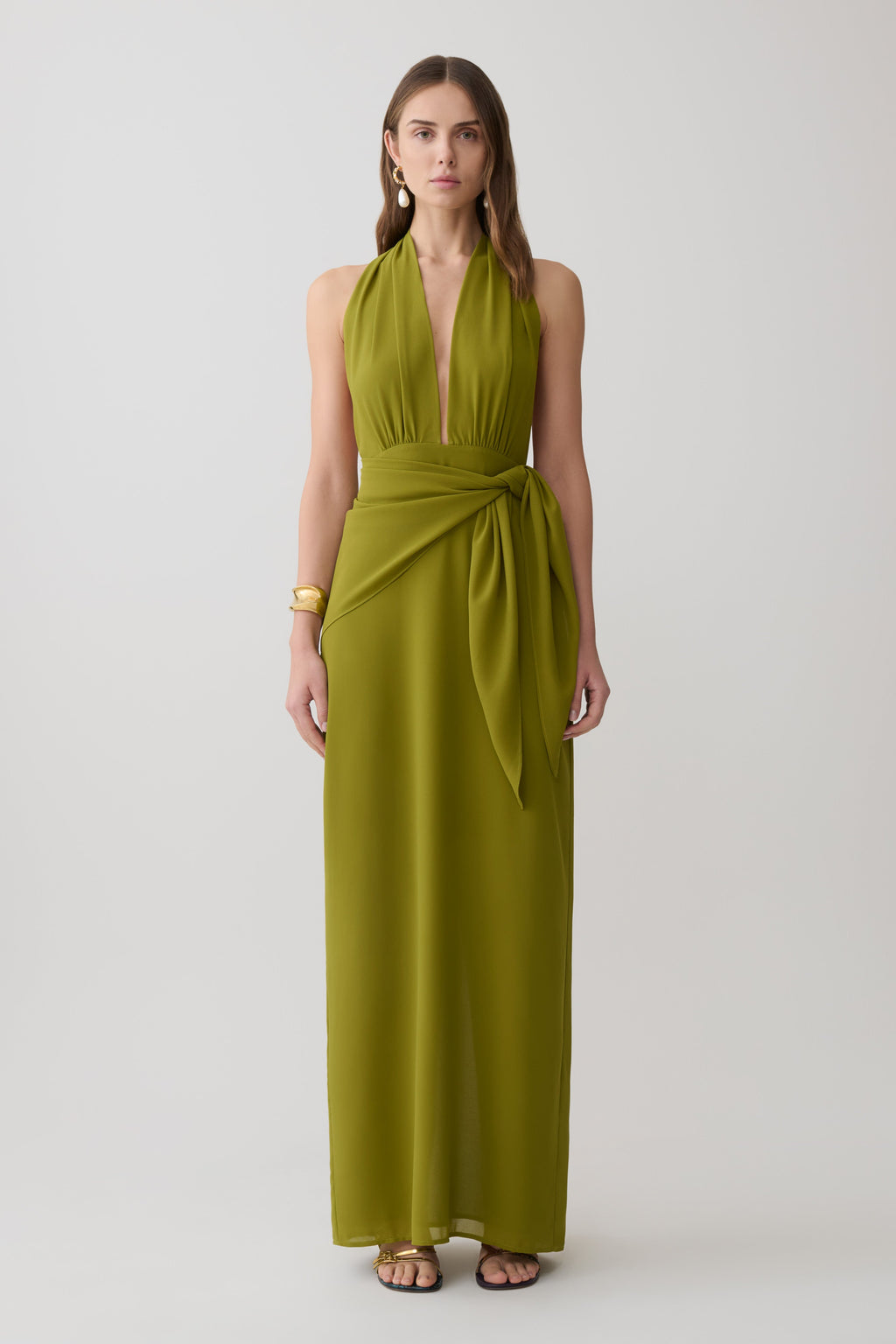 Woman wearing a green satin halter maxi dress.